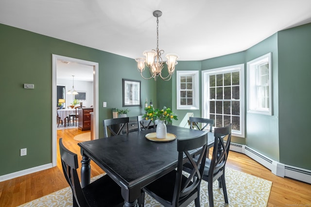 dining area featuring an inviting chandelier, light wood-style flooring, and plenty of natural light