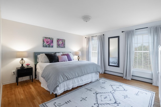 bedroom featuring a baseboard radiator and wood finished floors