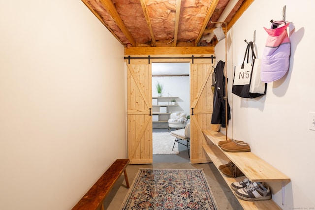 mudroom with a barn door and concrete floors