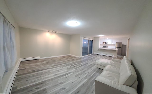 58 Henry St Unit 58, Norwich, CT 06360 - unfurnished living room with baseboard heating, light wood-style flooring, a baseboard radiator, and baseboards