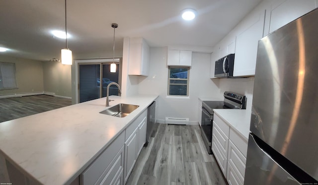 58 Henry St Unit 58, Norwich, CT 06360 - kitchen featuring appliances with stainless steel finishes, a sink, a baseboard radiator, light wood-style floors, and a peninsula