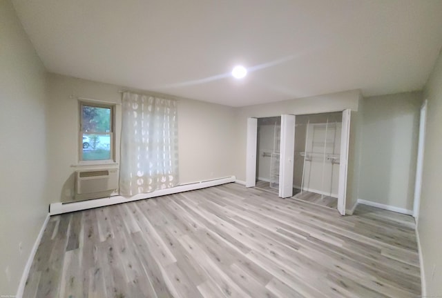 58 Henry St Unit 58, Norwich, CT 06360 - unfurnished bedroom featuring baseboards, wood finished floors, a baseboard heating unit, and a wall mounted AC