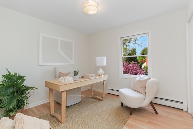 office featuring light wood finished floors and a baseboard radiator