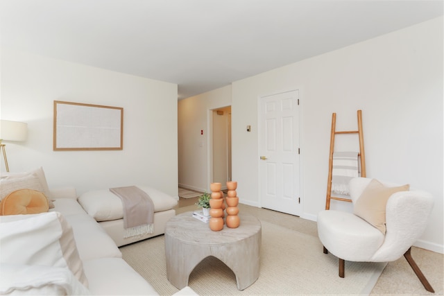 living area featuring baseboards and light colored carpet