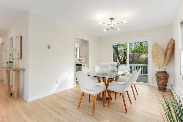dining room featuring a baseboard heating unit, baseboards, a chandelier, and light wood-style floors