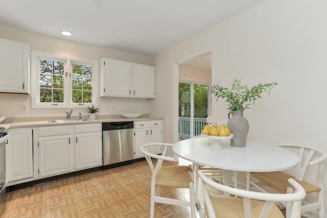 kitchen featuring light countertops, a healthy amount of sunlight, white cabinets, and dishwasher