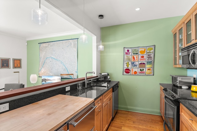 33 Hale Ln Unit 33, Darien, CT 06820 - kitchen with glass insert cabinets, appliances with stainless steel finishes, a sink, light wood-style floors, and dark stone counters