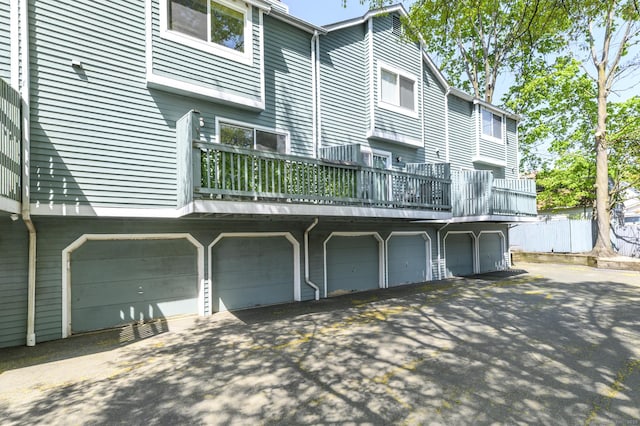 rear view of property featuring an attached garage and aphalt driveway