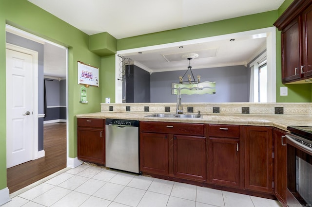 kitchen featuring light tile patterned floors, a sink, a peninsula, light countertops, and appliances with stainless steel finishes