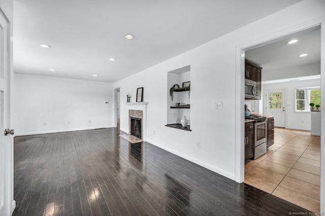 living area with a premium fireplace, recessed lighting, and hardwood / wood-style floors