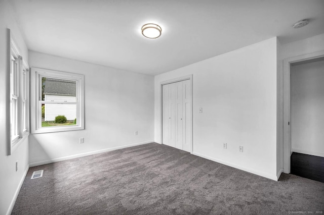 unfurnished bedroom featuring a closet, baseboards, carpet flooring, and visible vents