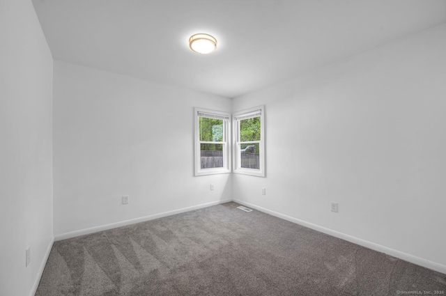 carpeted spare room with baseboards and visible vents