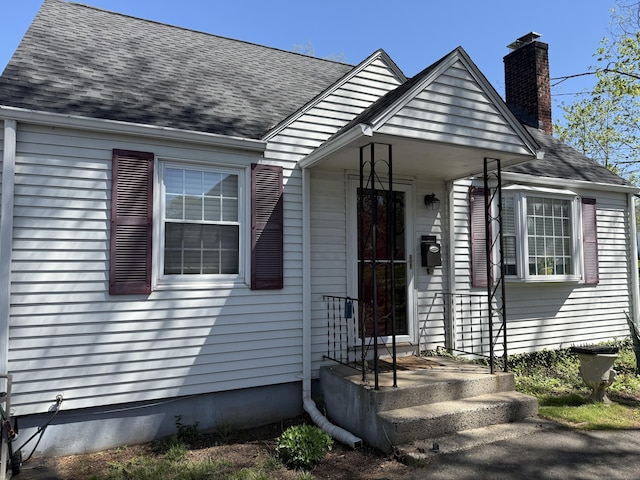 view of front of property with a chimney and roof with shingles