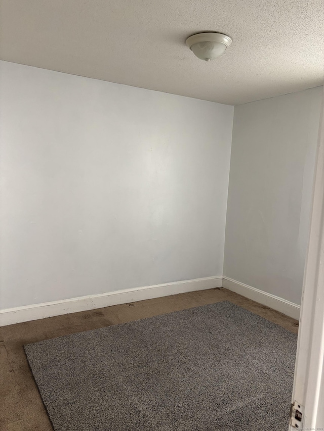 carpeted empty room featuring baseboards and a textured ceiling