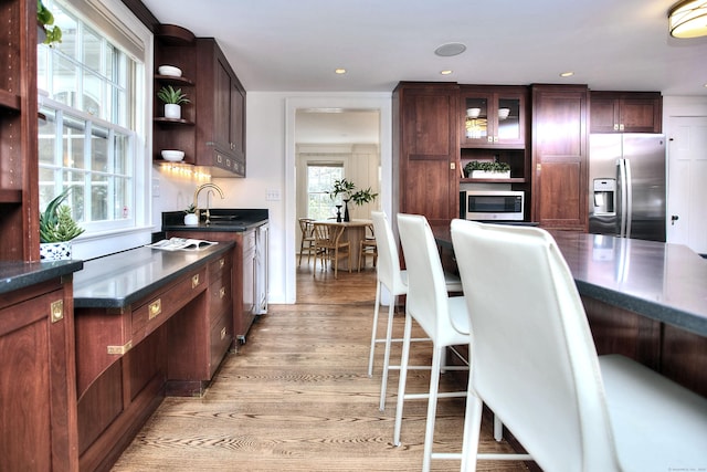 53 Sylvan Rd N, Westport, CT 06880 - kitchen with stainless steel appliances, open shelves, dark countertops, light wood-type flooring, and a sink