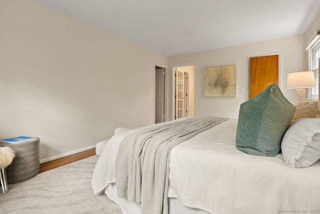 bedroom featuring baseboards and wood finished floors