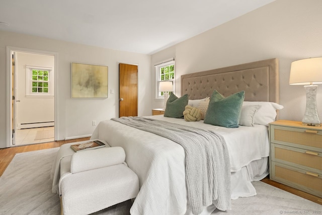 bedroom featuring wood finished floors and baseboard heating