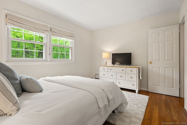 bedroom with wood finished floors and baseboards