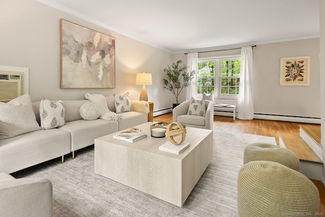 living room with a baseboard heating unit, ornamental molding, and light wood-type flooring