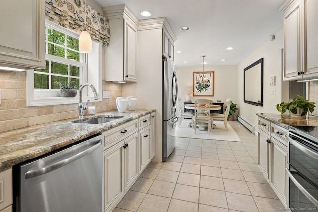 kitchen featuring stainless steel appliances, a sink, a baseboard heating unit, light tile patterned floors, and tasteful backsplash