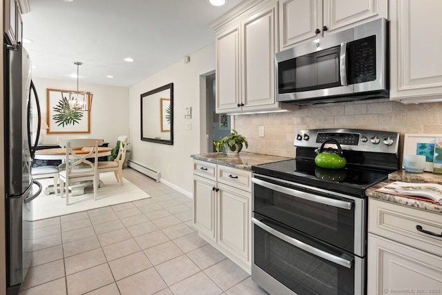 kitchen featuring appliances with stainless steel finishes, baseboard heating, decorative backsplash, baseboards, and light tile patterned floors