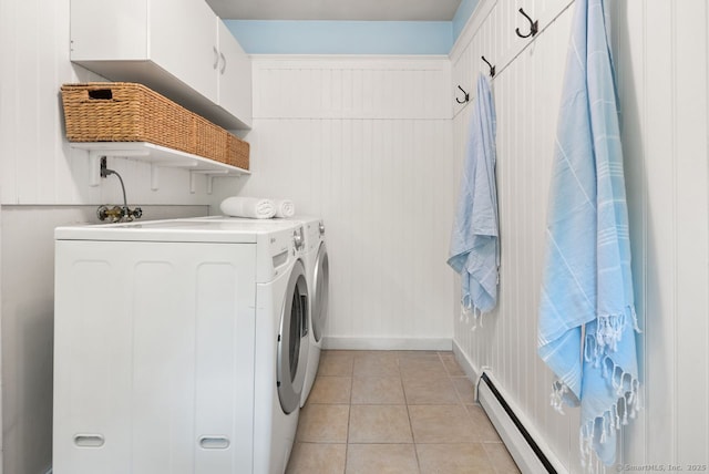 laundry room featuring washer and dryer, light tile patterned floors, a baseboard radiator, baseboards, and cabinet space