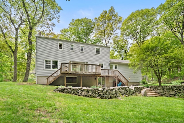 rear view of house with stairway, a wooden deck, and a lawn