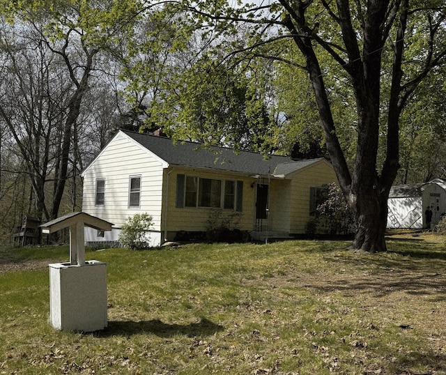 view of front of house featuring a chimney and a front lawn