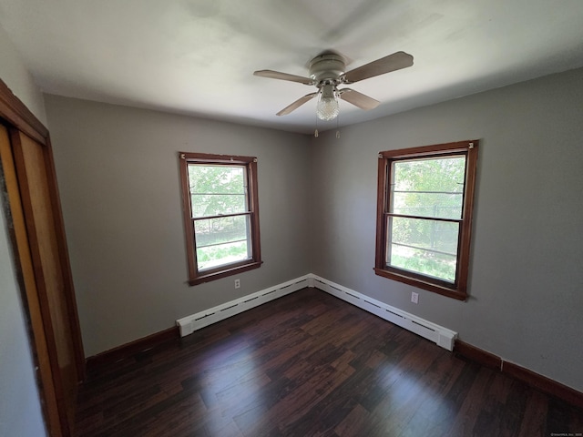 empty room with baseboard heating, a ceiling fan, baseboards, dark wood-type flooring, and a baseboard heating unit