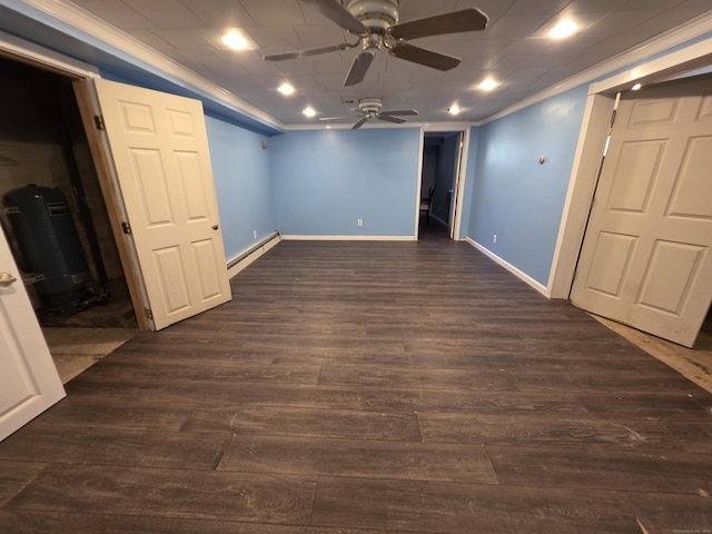below grade area featuring crown molding, baseboards, ceiling fan, baseboard heating, and dark wood-type flooring