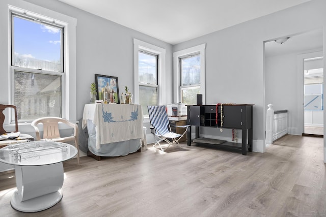 sitting room with a healthy amount of sunlight, baseboards, and wood finished floors