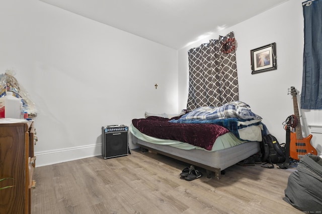 bedroom with baseboards and wood finished floors