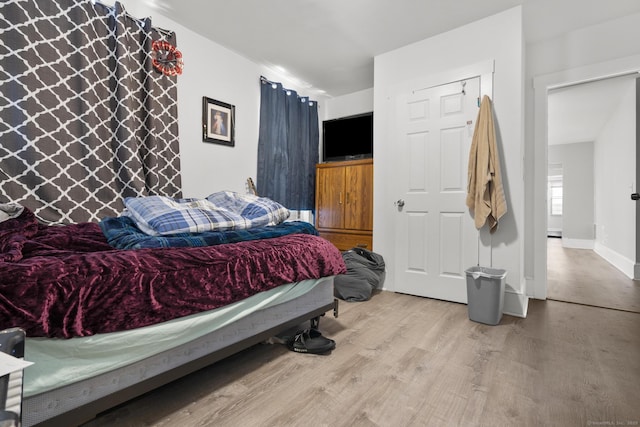 bedroom featuring baseboards and wood finished floors
