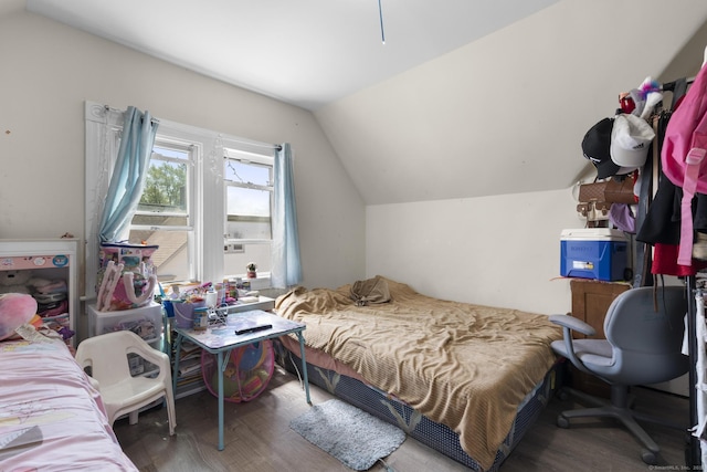 bedroom with wood finished floors and lofted ceiling