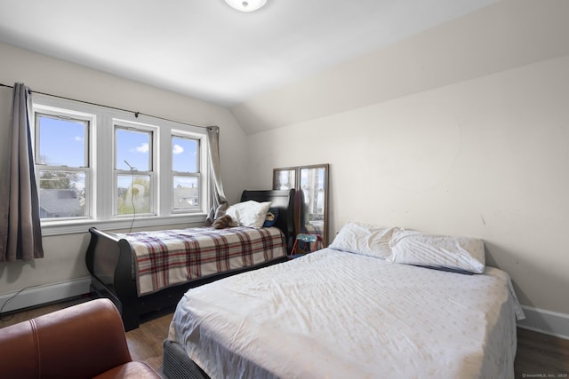 bedroom featuring baseboards, dark wood-style flooring, and lofted ceiling
