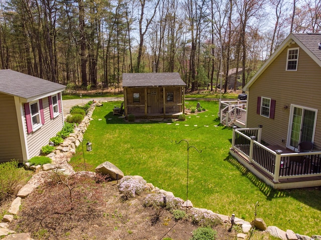 view of yard featuring a wooden deck and an outbuilding