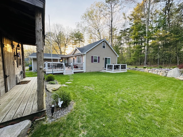 back of property with a lawn and a wooden deck