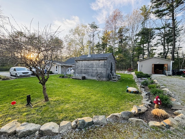 view of yard featuring a garage and an outbuilding