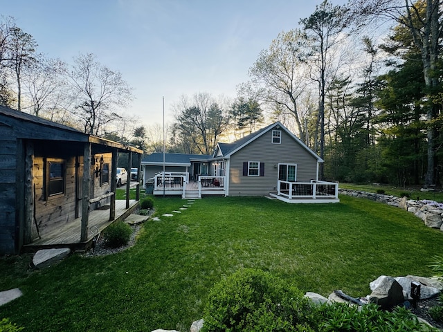 back of house featuring a lawn and a deck