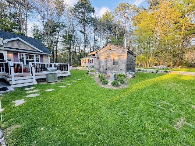view of yard featuring a deck and an outbuilding