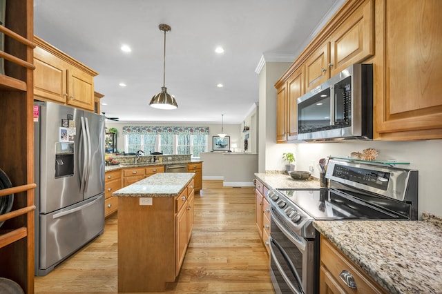 kitchen with a kitchen island, appliances with stainless steel finishes, light stone countertops, light wood finished floors, and ornamental molding