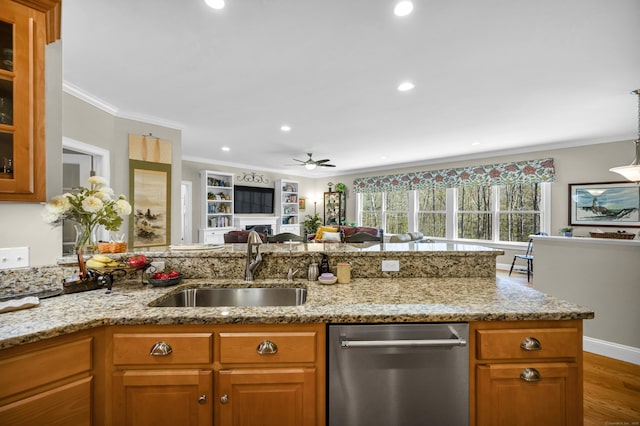 kitchen featuring crown molding, a sink, dishwasher, and light stone counters