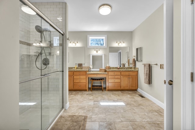 full bath featuring vanity, baseboards, and a shower stall