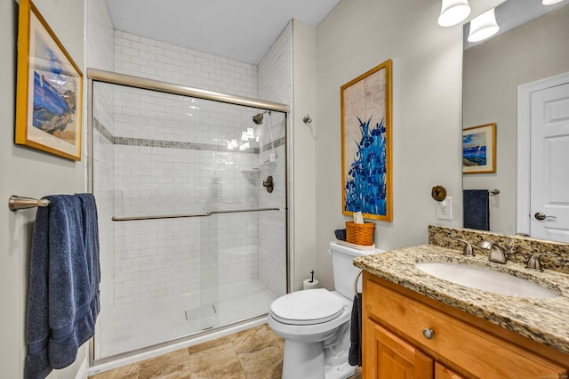 bathroom featuring vanity, a stall shower, and toilet