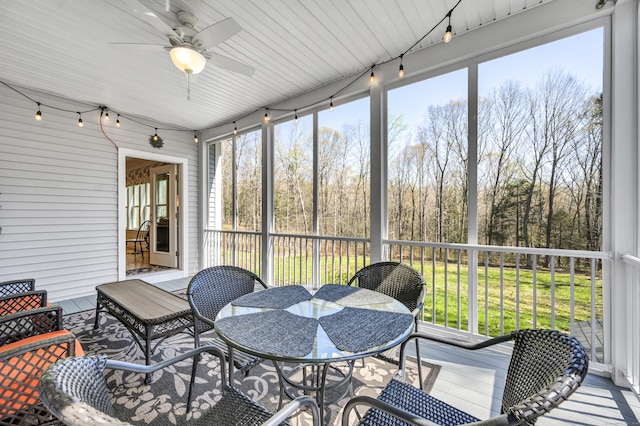sunroom / solarium with outdoor dining area and ceiling fan