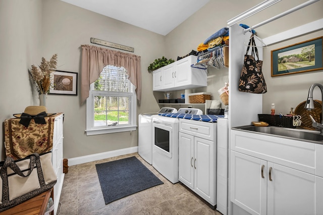 washroom with separate washer and dryer, a sink, cabinet space, and baseboards