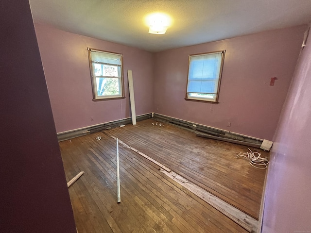 spare room featuring baseboards and hardwood / wood-style floors