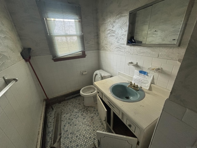 bathroom featuring tile walls, tile patterned flooring, wainscoting, vanity, and toilet