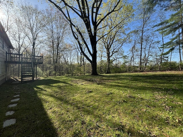 view of yard with a wooden deck and stairs