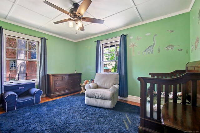 836 Prospect Ave, Hartford, CT 06105 - bedroom with wood finished floors, a crib, crown molding, ceiling fan, and baseboards
